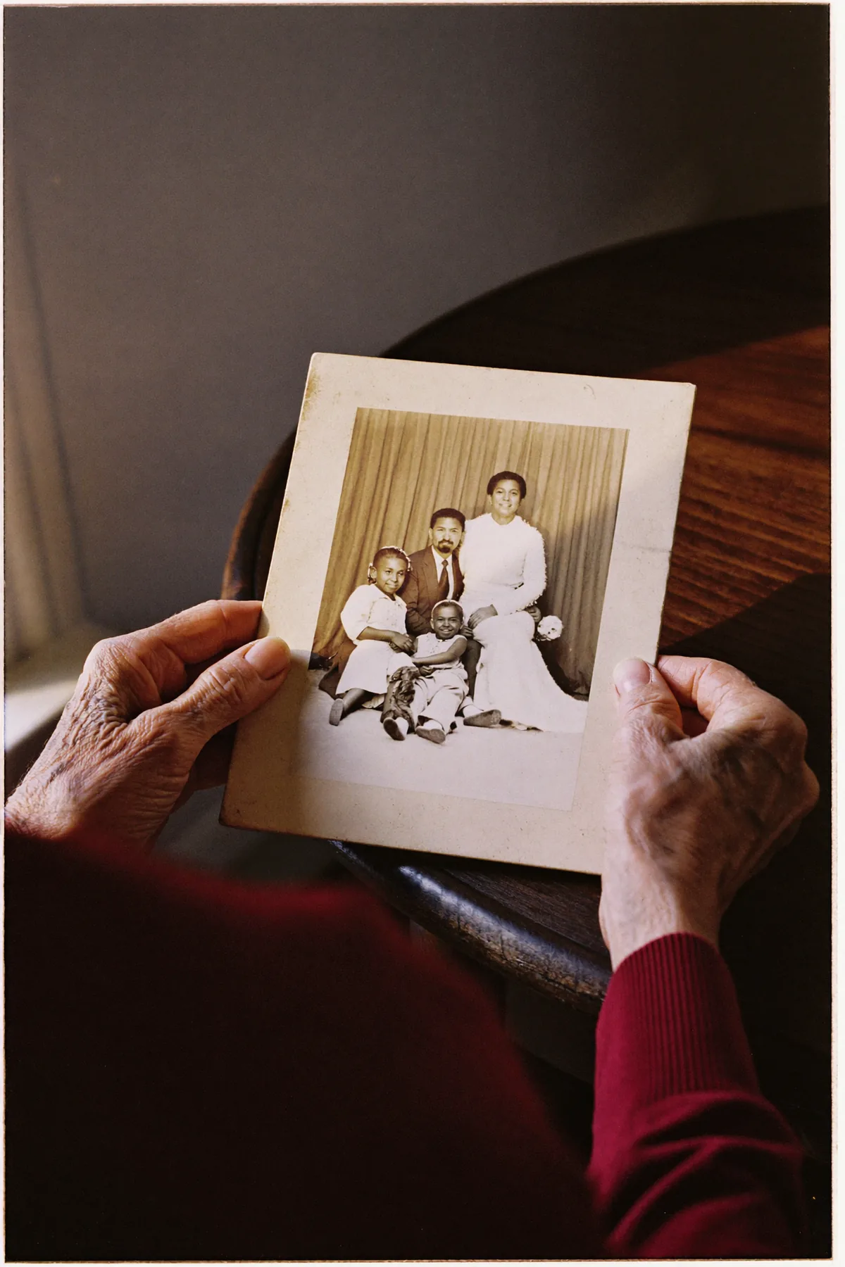 Hands holding a faded family photograph
